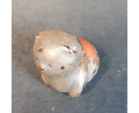 A 19thC Japanese painted wood netsuke study of a puppy.