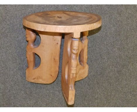 An African circular stool with carved decoration depicting soldiers.