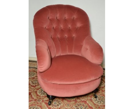 Victorian upholstered deep buttoned back armchair on turned ebonised supports with brass and ceramic castors