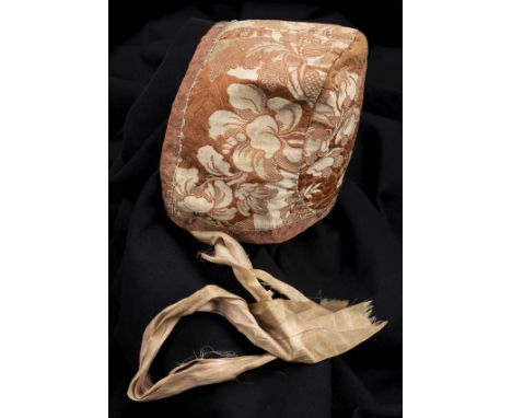 *Bonnet. An infant's bonnet, mid 18th century,  hand-stitched orange and cream silk brocade bonnet, composed of three joined 