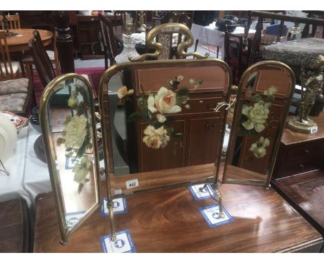 A brass triple fire screen with hand painted mirror insets.