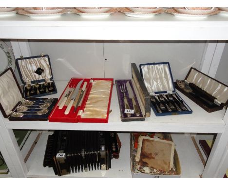 A shelf of cased cutlery.