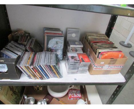 A shelf of CD's, DVD's, tapes and 45 rpm records.