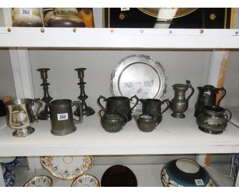 A shelf of metalware including pewter.