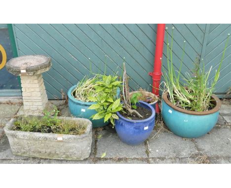 A concrete garden bird bath, 63cm tall, together with a concrete garden trough, 70cm wide, and four glazed ceramic garden pla