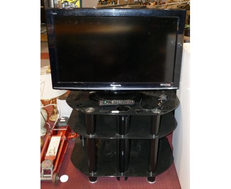 A Panasonic 32 inch LCD TV, model TX 10 BA, together with a smoked glass TV/Hi-Fi stand and remote.