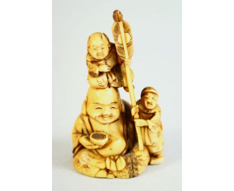 A JAPANESE CARVED IVORY NETSUKE, depicting buddha with children, signed to base, 6cm high.