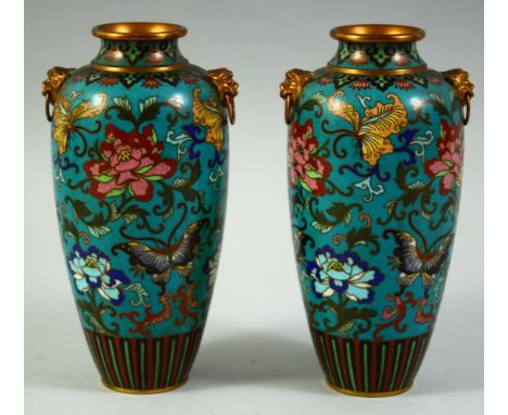 A PAIR OF CHINESE CLOISONNE TWIN HANDLE VASES, the body of each decorated with flora and butterflies, with two foo dog ring h