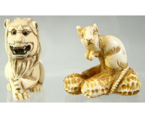 A JAPANESE CARVED IVORY NETSUKE of a rat seated on a group of nuts, together with a netsuke of a seated lion, 4cm and 4.5cm h