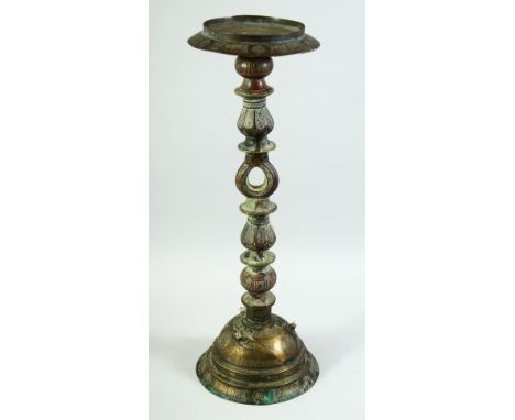 AN ISLAMIC ENGRAVED BRASS LAMP STAND, engraved with calligraphy and various motifs, 55.5cm high.