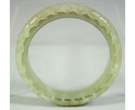 A CHINESE CARVED AND PIERCED JADE BRACELET, 8cm diameter.