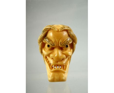 A JAPANESE CARVED IVORY NOH MASK NETSUKE, signed to the reverse, 4.5cm.