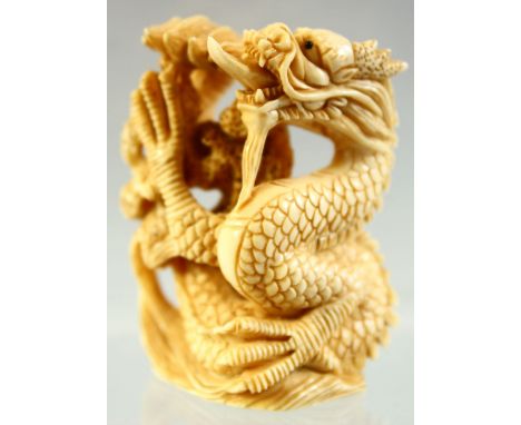 A JAPANESE CARVED IVORY NETSUKE OF A DRAGON, signed to base, 4.5cm high.