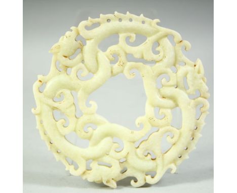 A LARGE CARVED AND PIERCED NEPHRITE JADE / HARDSTONE DRAGON DISK, 14cm diameter.