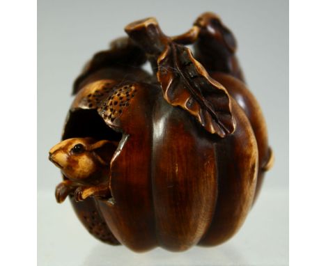 A SMALL JAPANESE WOOD CARVING / NETSUKE of a pumpkin with two mice, one reticulated mouse emerging from inside the pumpkin, s