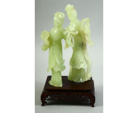 A CHINESE JADE FIGURAL GROUP ON A HARDWOOD STAND, the jade carved as two female figures, mounted to a carved and pierced hard