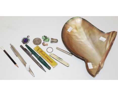 Quantity of various collectables in a pearl shell comprising 3 pens including Parker, medallions, pen knife, silver thimble, 