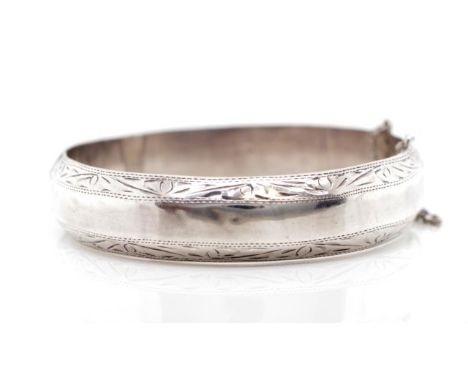 Sterling silver hinged bangle with bright cut engraved edges, box clasp and safety chain. Marked 925, inside width 60mm, weig