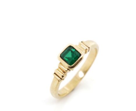 Created emerald and 9ct yellow gold ring marked 375. Approx weight 3.9 grams, ring size Q. Surface wear to the table of the s