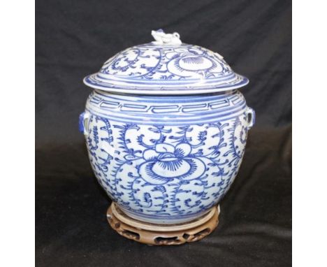 Antique Chinese blue and white lidded pot with floral decoration and foo dog finial, on a carved timber stand, height 26cm ap