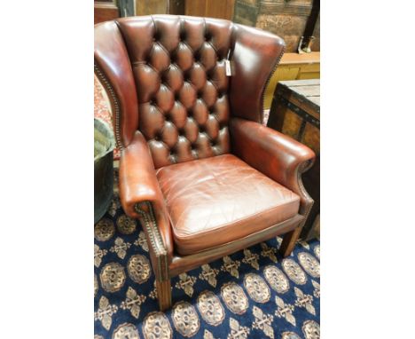 A George III style button back burgundy leather wing armchair, width 83cm, depth 66cm, height 82cm