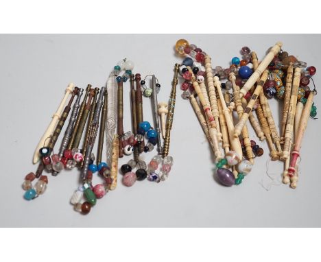 Twenty ornate 19th century turned bone and beaded topped lace bobbins and eleven ornately turned metal lace bobbins, glass bo