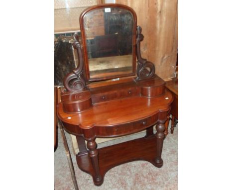 A 3' 5" Victorian mahogany duchess dressing table with swing mirror, pierced scroll supports, trinket drawer and flanking lif