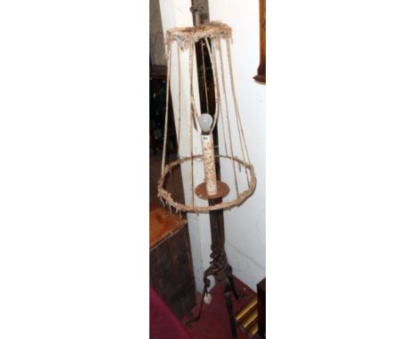 An old wrought iron standard lamp in the form of a torchère with open twist column and ornate tripod base - complete with rem