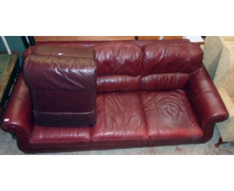 A 7' 3" modern three seater settee upholstered in oxblood coloured leather - sold with an associated pouffe 