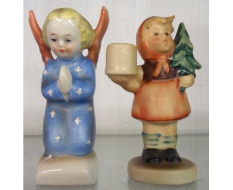 A pair of Hummel figures of an angel praying and a girl carrying a small Christmas tree