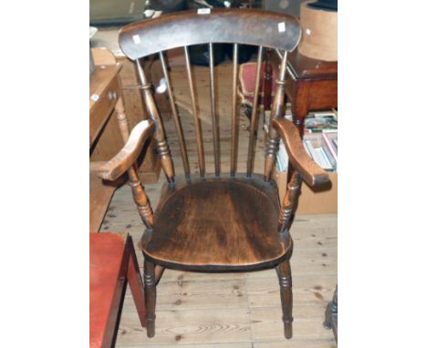 An elm Windsor stick back elbow chair with moulded solid elm seat, set on ring turned supports