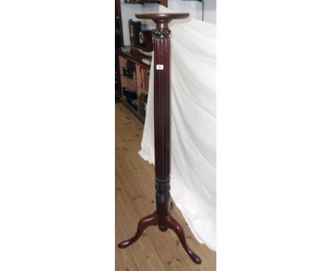 An antique mahogany torchère formed from a tester bedpost, set on tripod base with pad feet