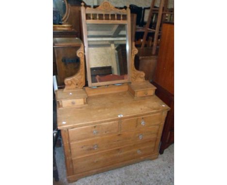 A 3' 5 1/2" late Victorian waxed pine dressing chest with swing mirror, incised supports and flanking trinket drawers over tw