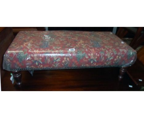 A 33" reproduction Victorian style duet footstool by Past Times of Wales with decorative tapestry upholstery, set on polished