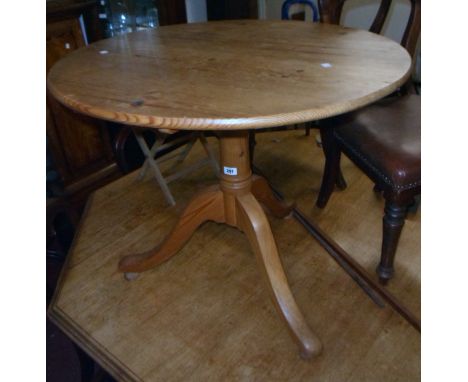 A 33" diameter waxed pine bird cage table, set on turned pillar and tripod base