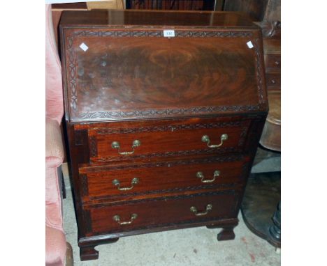 A 29 1/2" 20th Century flame mahogany veneered bureau, with blind fretwork decoration, part fitted interior and three long gr