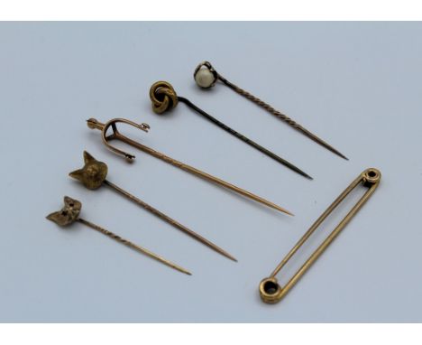 A 9ct gold stock pin, a 9ct gold fox mask stick pin and four unmarked yellow metal stick pins, including stirrup etc