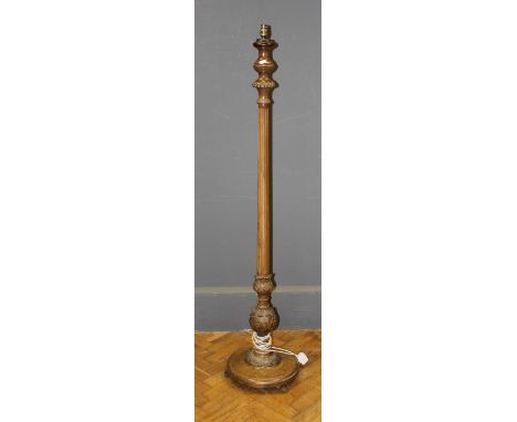 An early 20th century carved beech standard lamp raised on a circular base and panel feet together with two shades, height of