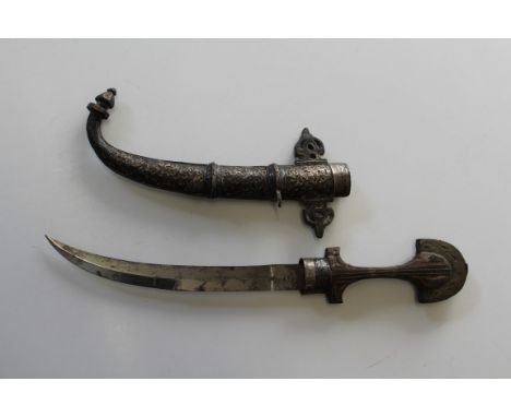 A late 19th/ early 20th century Jambiya, the carved wood gilt metal mounted grip above a 23cm double edge steel blade, in flo