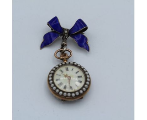 A yellow metal enamel ladies pocket watch featuring enamelled pansy and seed pearls. Suspended from a blue enamel and pearl b