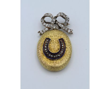 An Edwardian 18ct gold locket with blue enamel and diamond horseshoe detail, suspended from a diamond set bow with pin. Gross