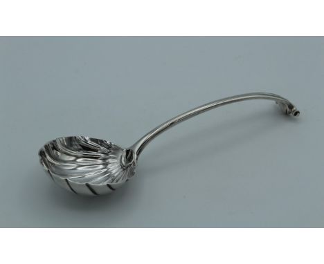 A George III silver sauce ladle with scallop bowl and scroll terminal. London marks rubbed, 17cm