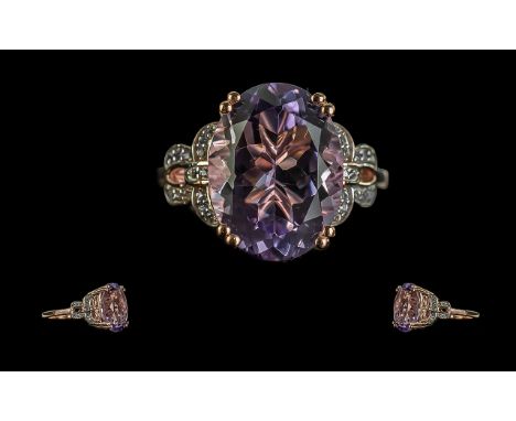 Amethyst Designer Style Ring. an oval cut amethyst of over 9cts, set in an openwork, decorative, gallery mount, the stone hel