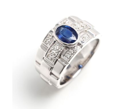White gold 750, 11.3 g. Sporty-elegant ring, the obverse side set with 1 oval sapphire of approx. 1.0 ct and 20 diamonds in 8