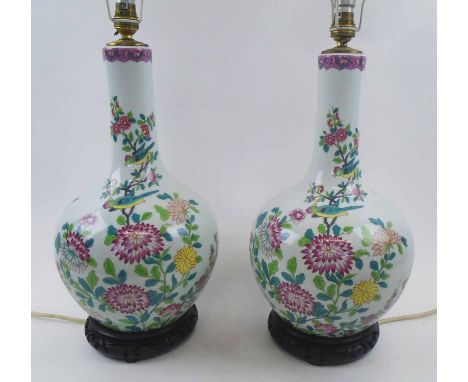 CHINESE CERAMIC BOTTLE VASE LAMPS, a pair, each decorated chrysanthemums in colours, wooden bases, 42cm H plus shades. (2)