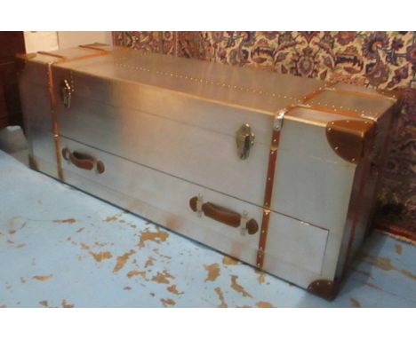 AVIATOR STYLE LOW TRUNK, tan leather bound with a rectangular rising top enclosing space for storage, a handle to each side a