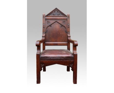  Gothic Revival oak armchair carved with arch, quatrefoil and trefoil motifs, upholstered leather seat.    