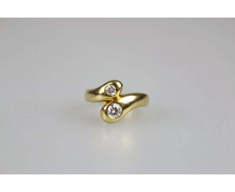 Ring mit zwei Diamanten, 750er Gelbgold, gepunzt, Schiene mit übereinander geschobenen Enden am Ringkopf, besetzt mit je eine