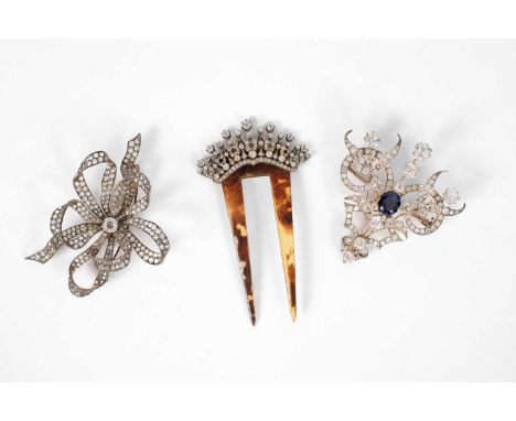 A tortoiseshell and paste hair comb, 14cm and two large white metal and paste brooches, 19th Century and later (3)