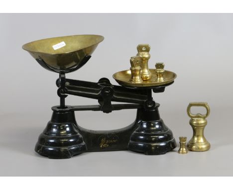A set of kitchen weighing scales and brass weights.